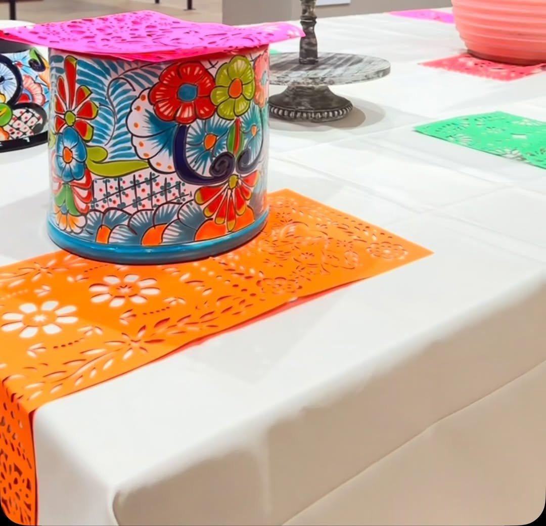 A corporate event table set by Gaelos with a talavera centerpiece and orange papel picado