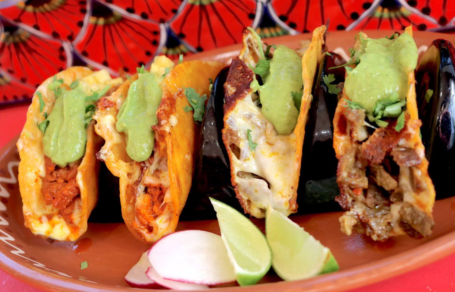 Quesatacos topped with guacamole salsa, served with lime